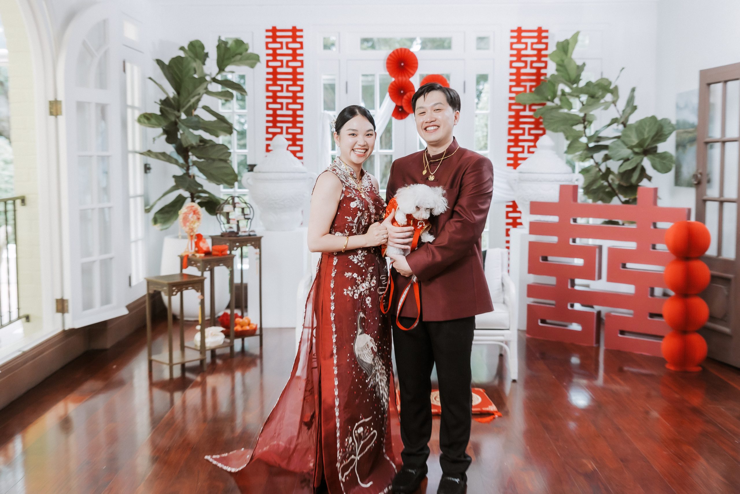 Couple at a Chinese tea ceremony with a double-happiness backdrop