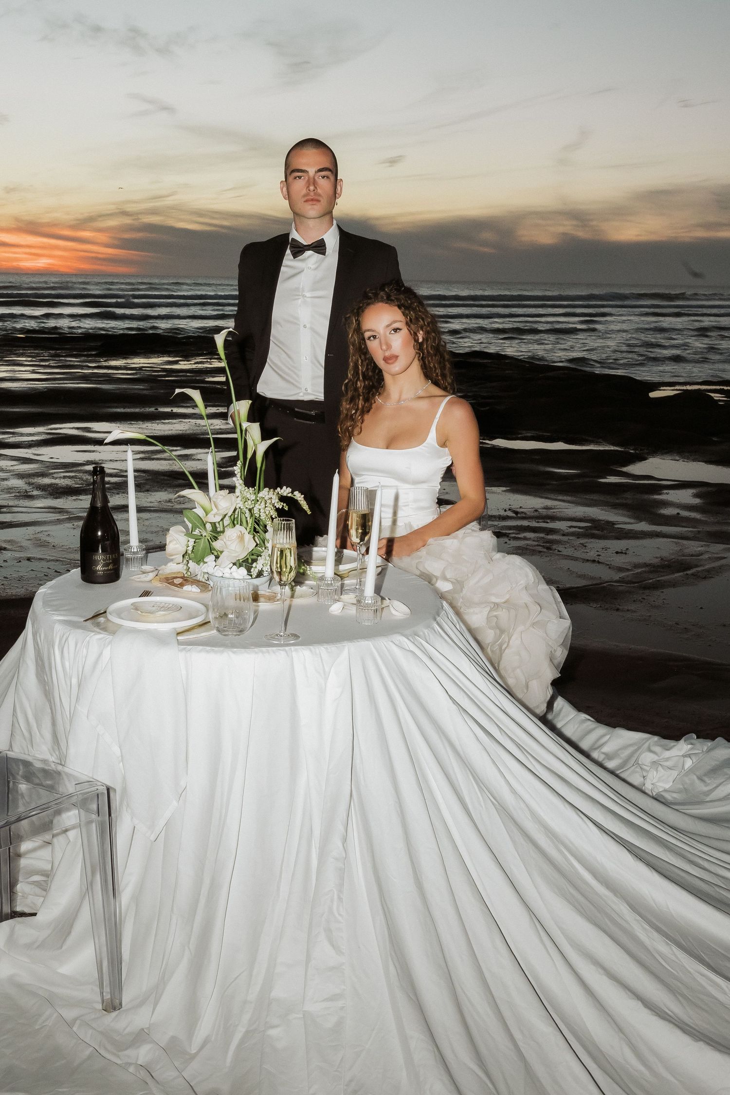 Bride and groom on the Karioitahi clifftop at sunset