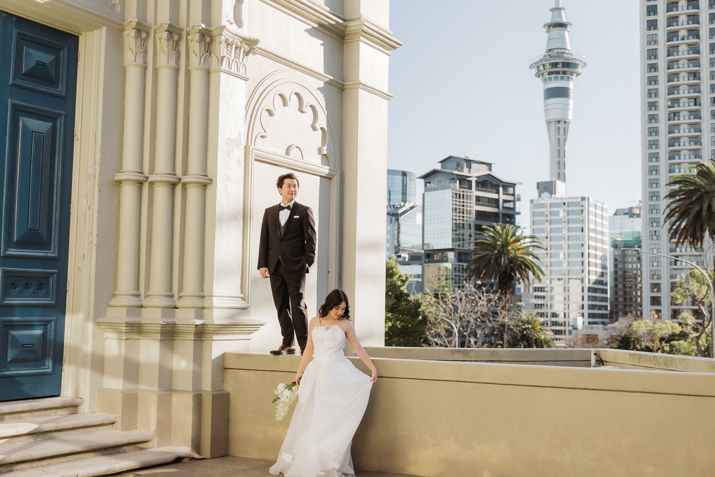 Bride and groom on a heritage terrace above the CBD, Sky Tower behind them