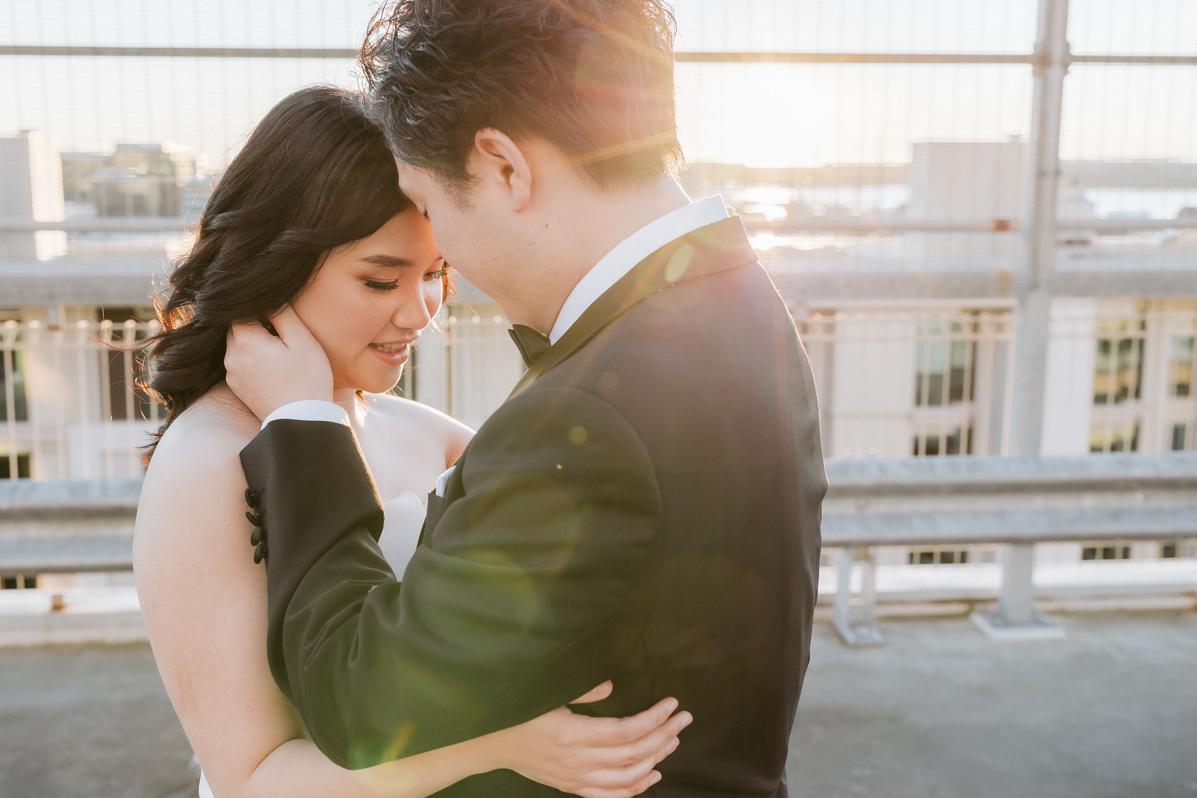 Wedding couple on an Auckland rooftop at golden hour with the Sky Tower behind