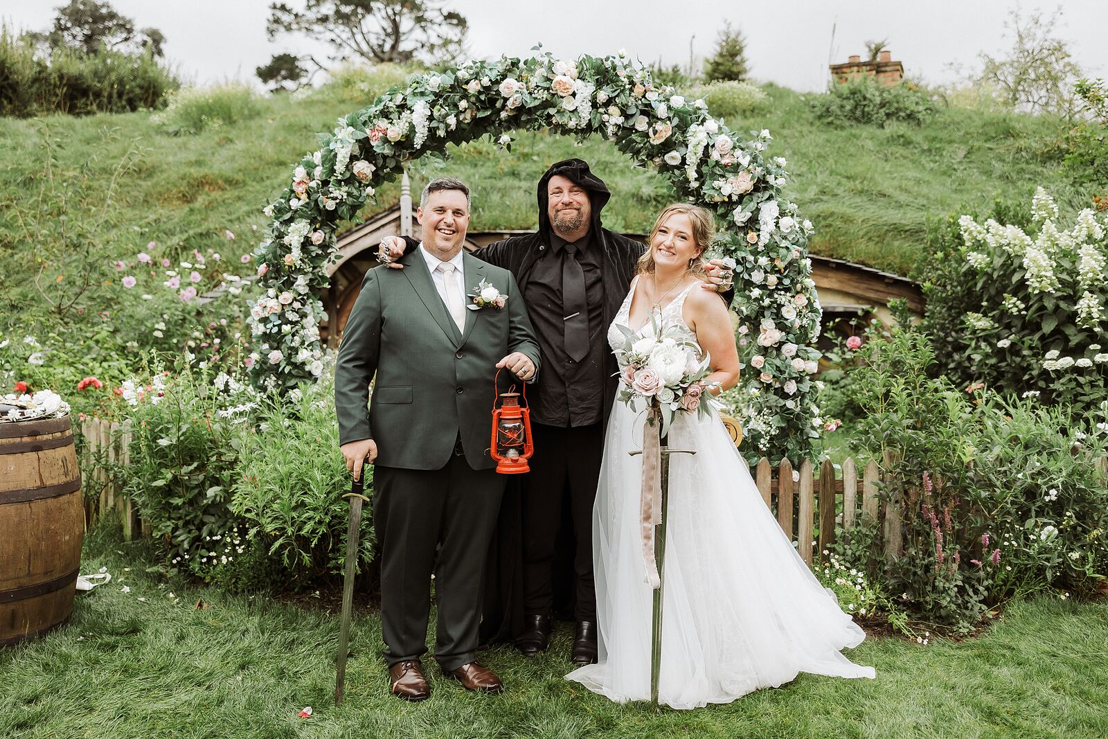 Bride and groom kissing under the floral arch at their Hobbiton ceremony