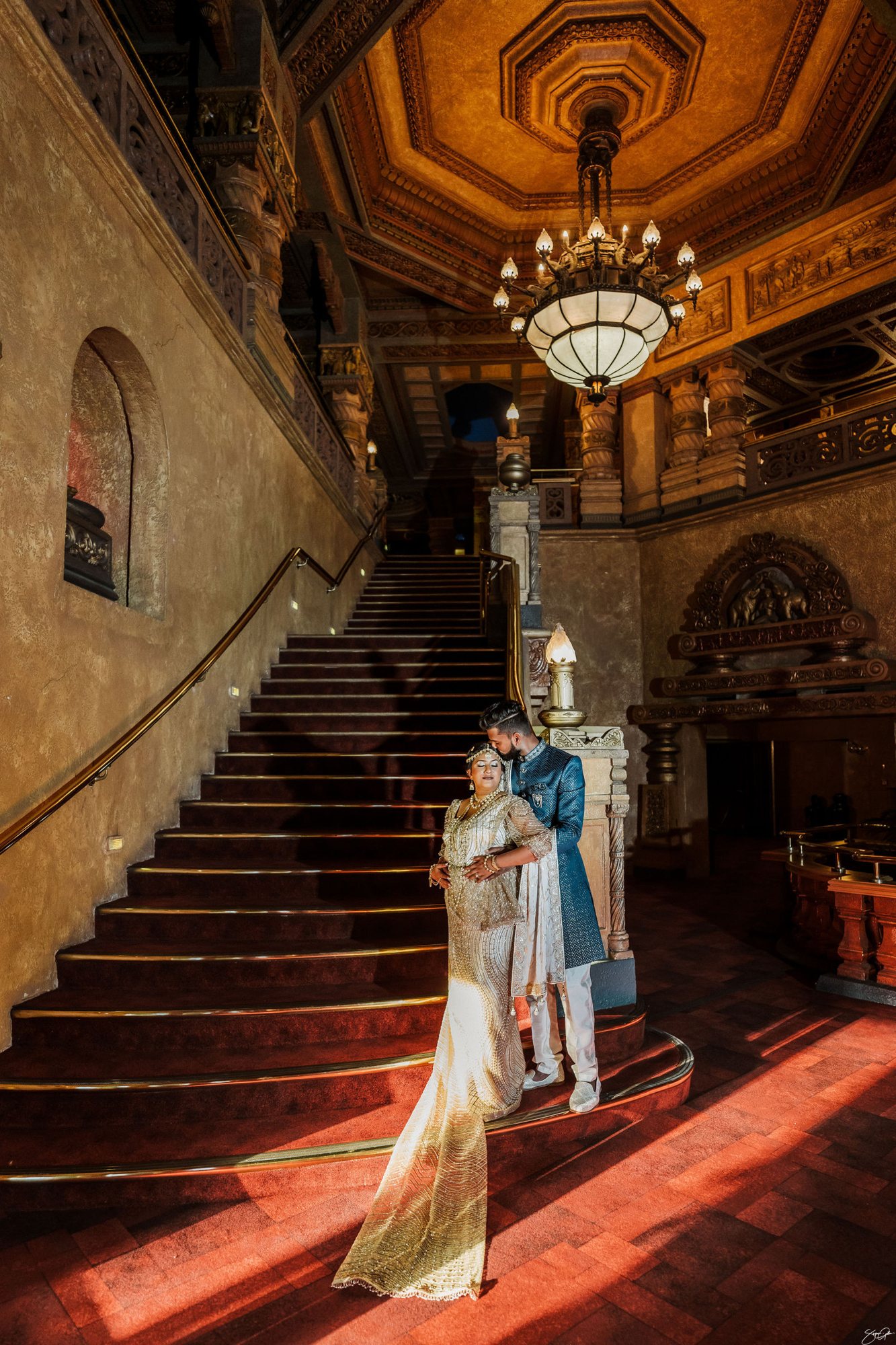 Indian bride in gold lehenga on the Auckland Town Hall staircase