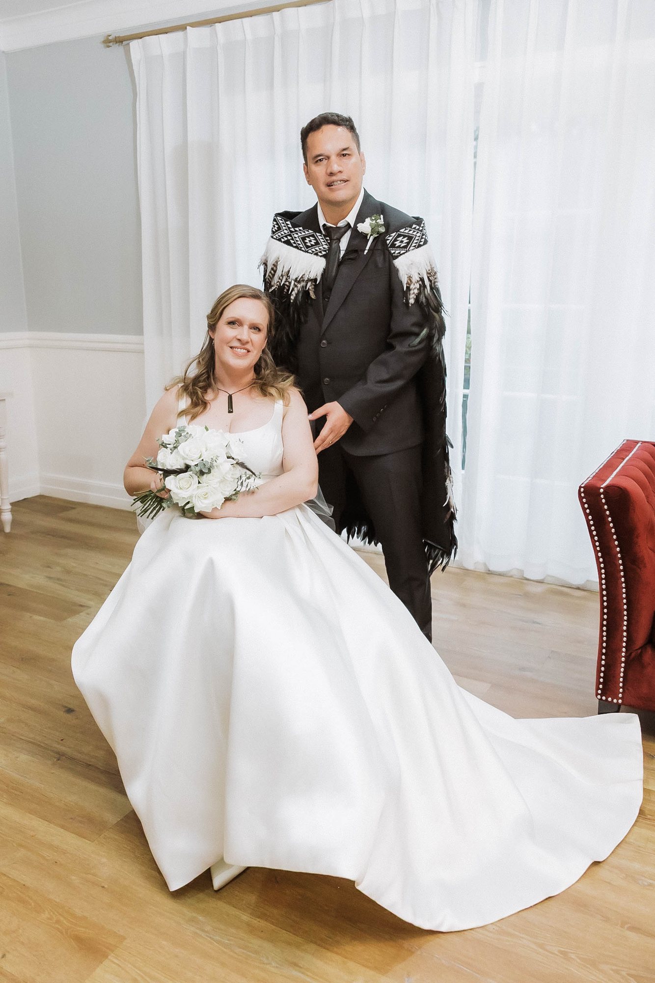 Groom wearing a korowai standing with his bride at an Auckland Māori wedding