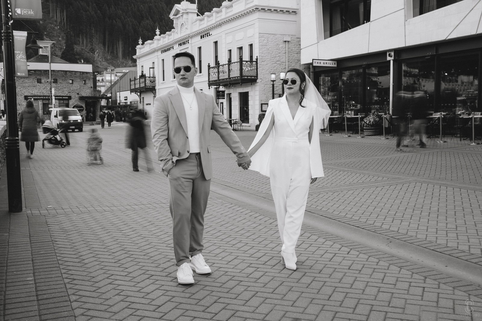 Couple walking hand in hand through Queenstown town centre