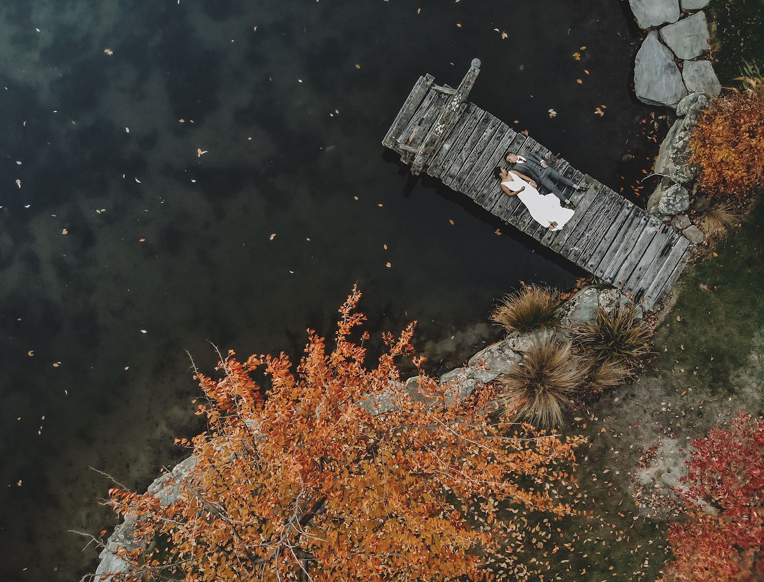 Aerial view of a couple on a lake jetty in autumn