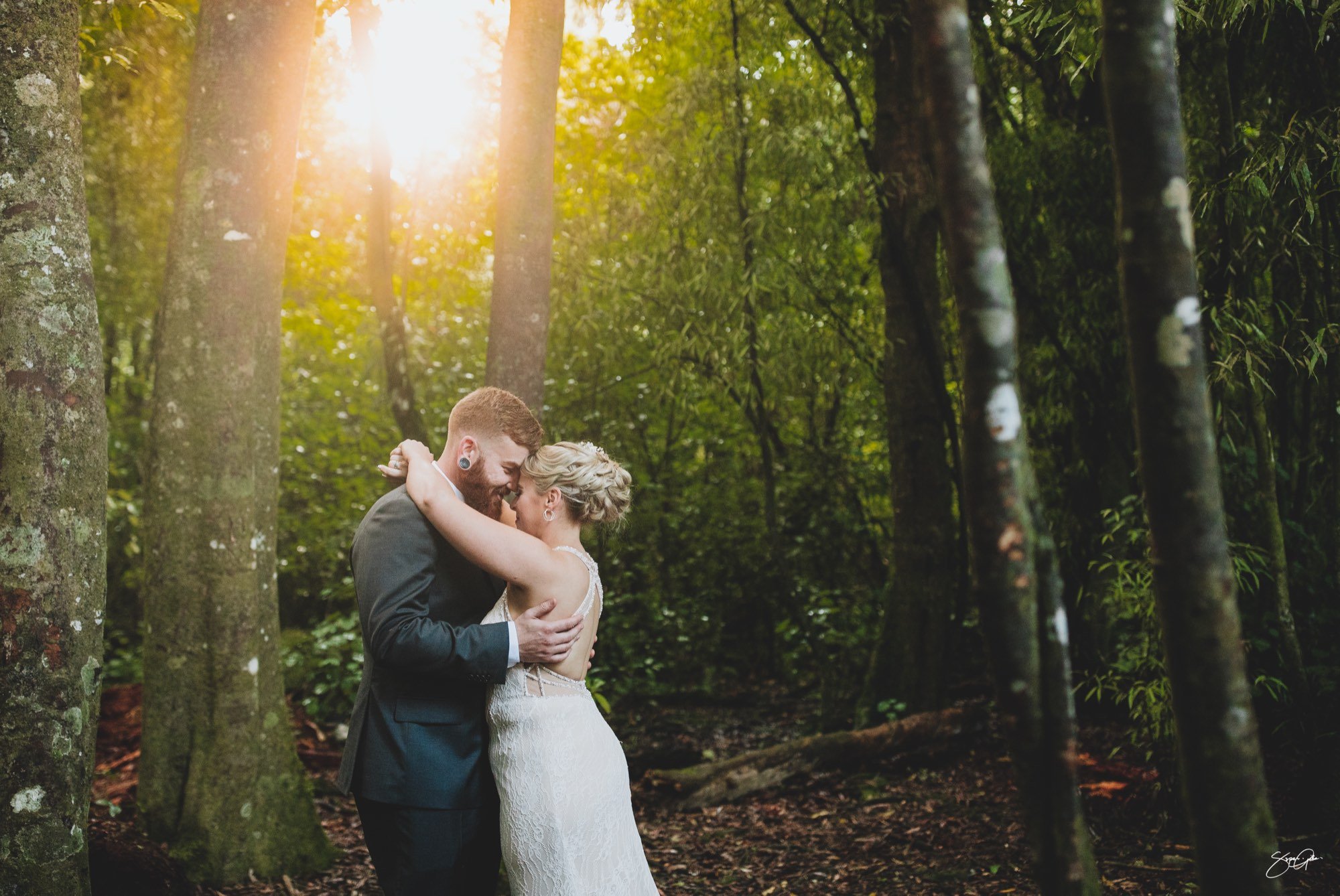 Bride and groom embracing in an Auckland forest — SuperGibo wedding photography