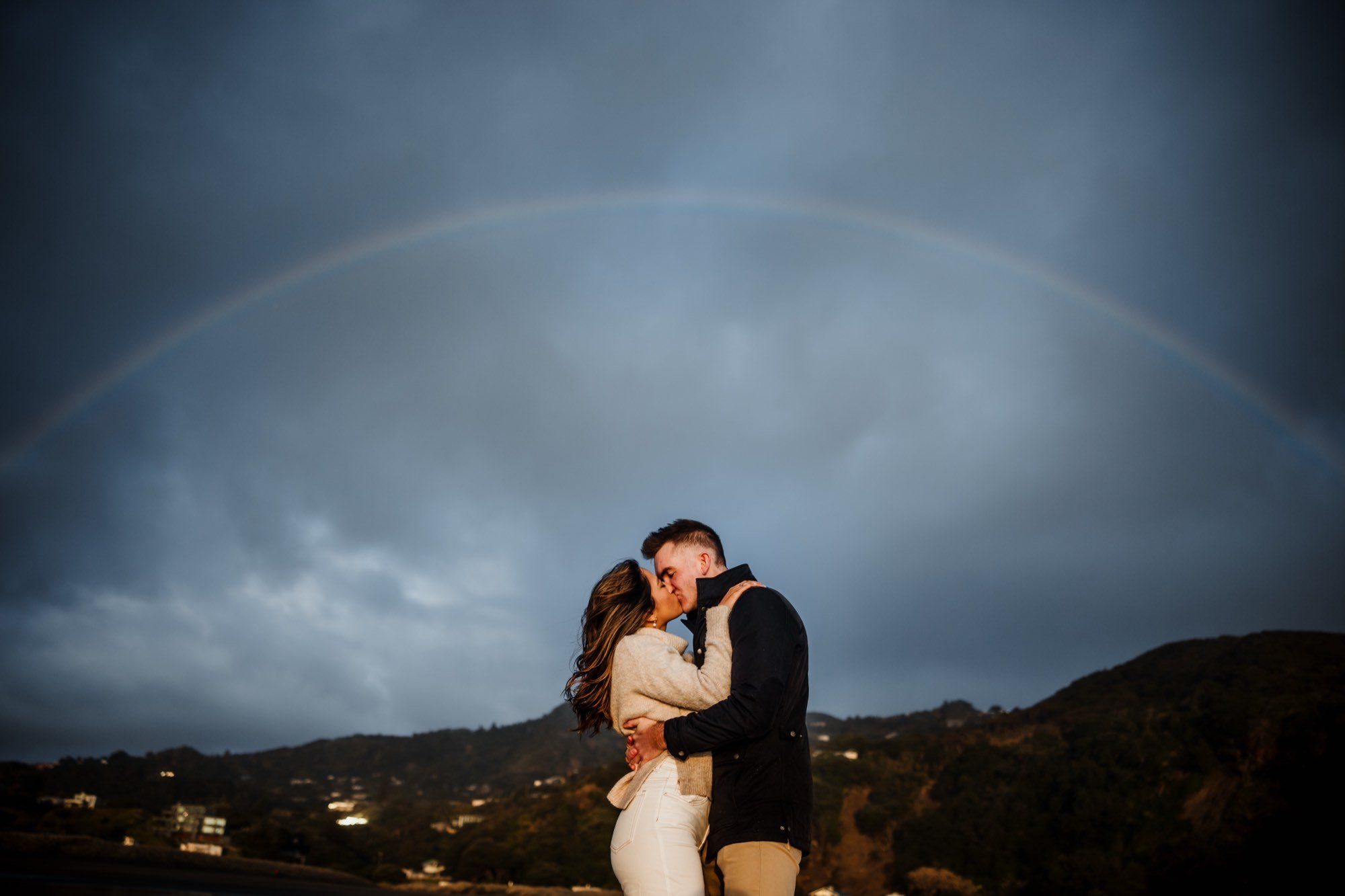 Couple kissing under a rainbow — engagement session by SuperGibo Photography