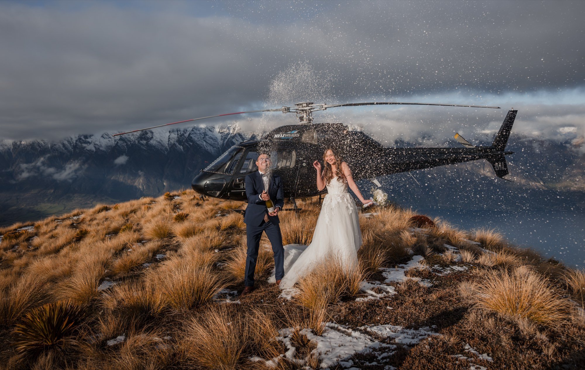 Champagne celebration beside a helicopter above Queenstown
